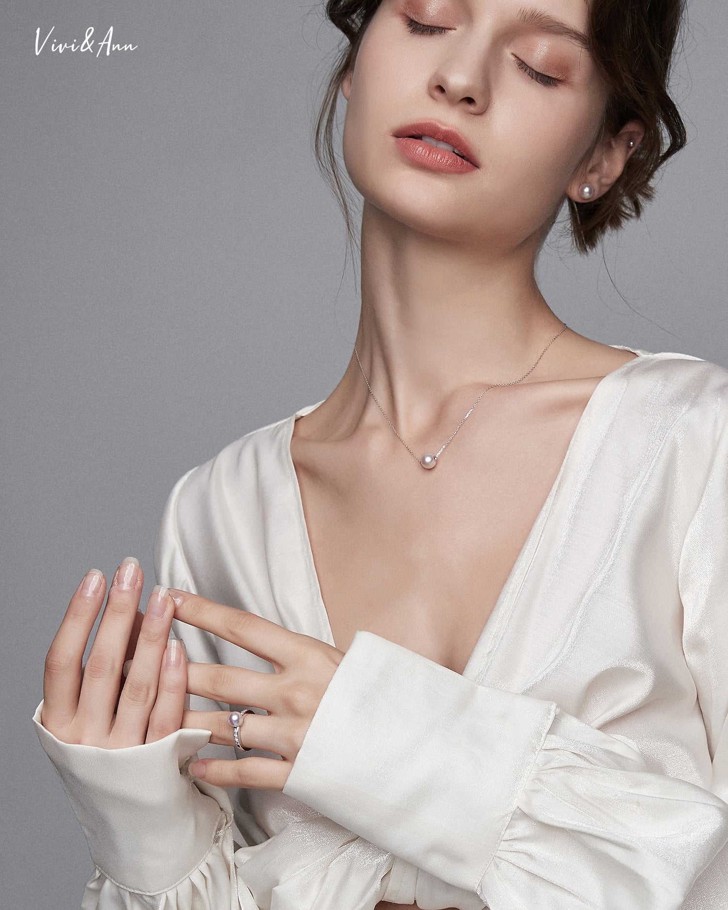 Lady wearing pearl necklace, earrings and ring